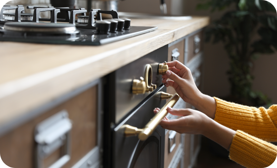 Hands using the knobs on a gas stove