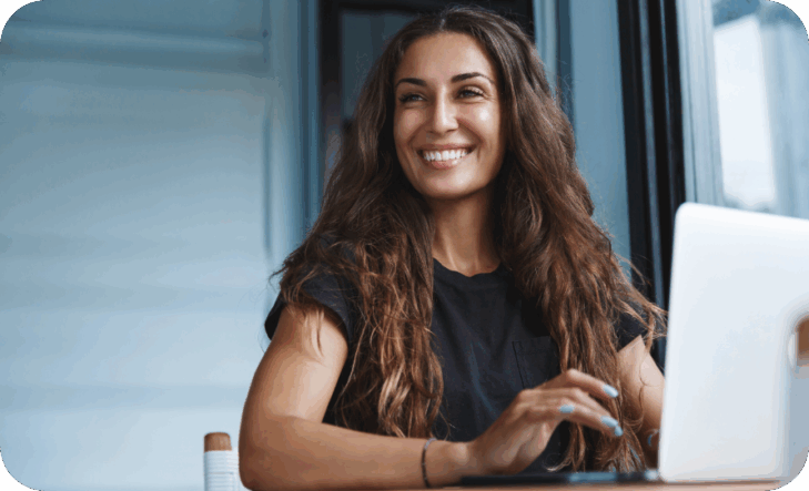 A woman seated at a desk using a laptop