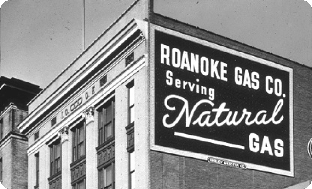 Black and white photo of the Roanoke Gas Company sign on the side of a building