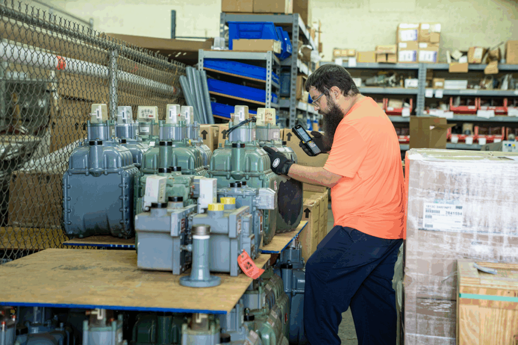 A man standing in a workshop looking at some equipment.