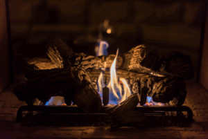 Closeup of a lit gas log fireplace.