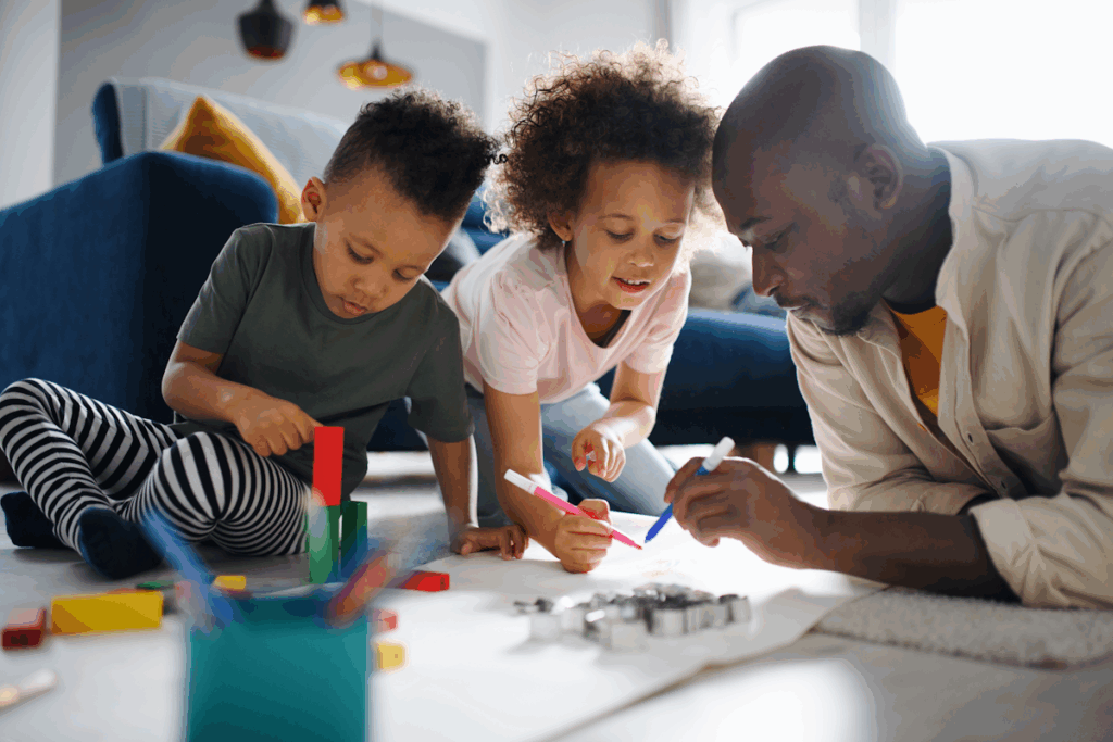 A man and two young children playing on the floor of a living room.