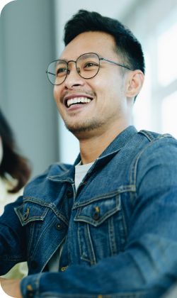A person wearing a jeans jacket and glasses